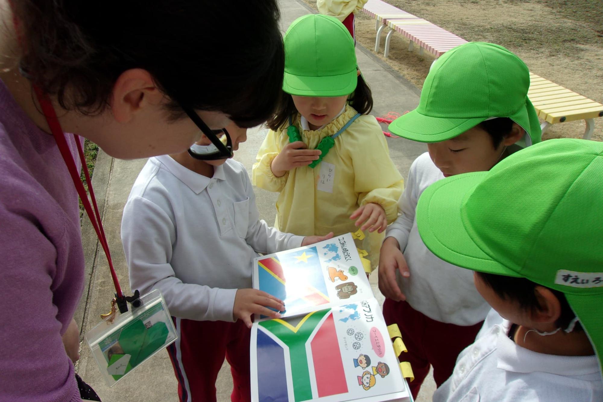 国旗の本を見せてあげる園児