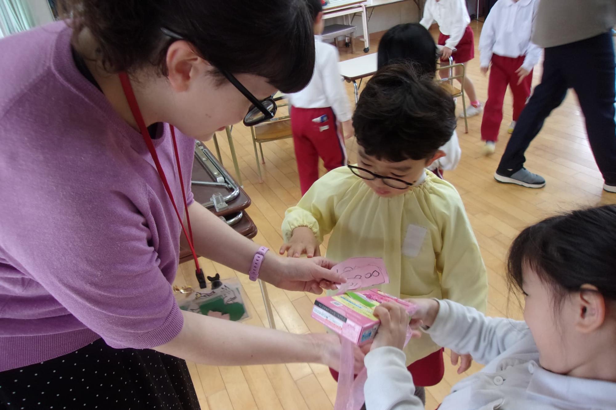 折り紙で作った工作を見せる園児