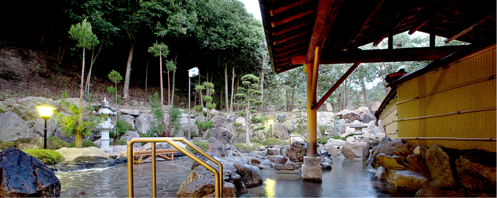 石灯篭や大きな岩が配置され庭園風の和情緒あふれる造りとなっている、和気鵜飼谷温泉の露天風呂の写真